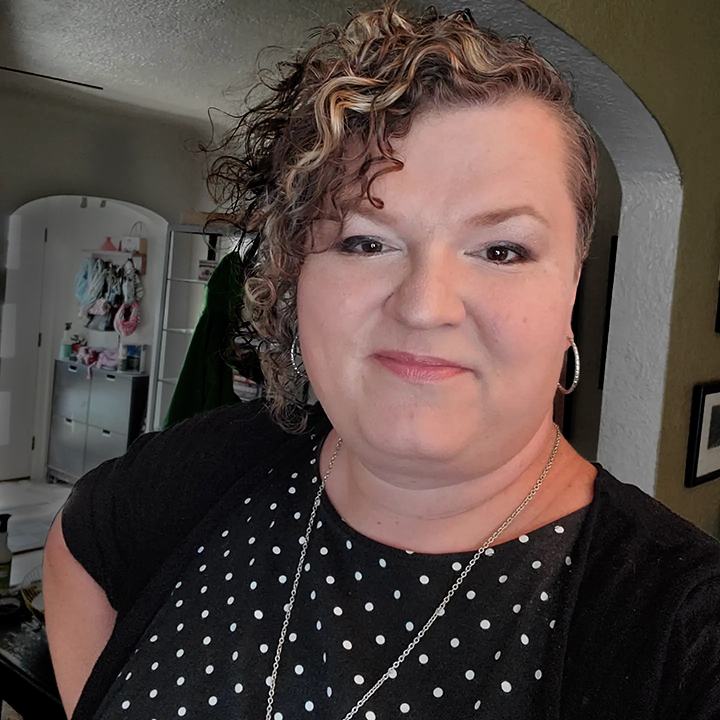 A photo of Josie Cool Smiling while wearing a black and white polka-dot dress