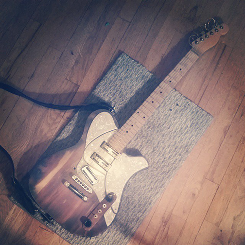 An image of Josie Cool Guitar Works #005, a telecaster inspired electric guitar, laying on a wood floor.