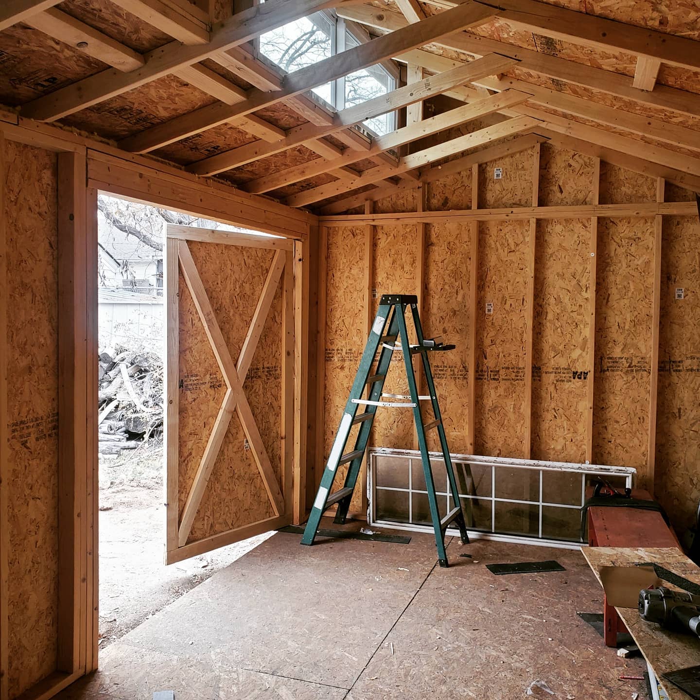 An inside view of the shed showing rafters and front doors